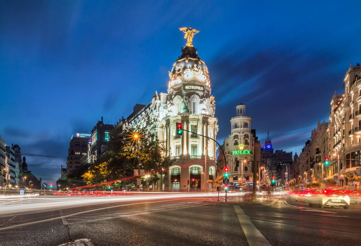 The Metropolis building on Gran Vía at blue hour, with light trails of passing cars